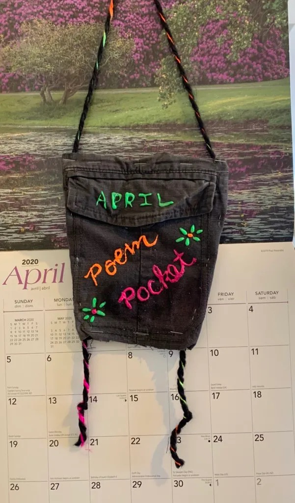 Black cloth back with puffy paint that says April Poem Pocket.