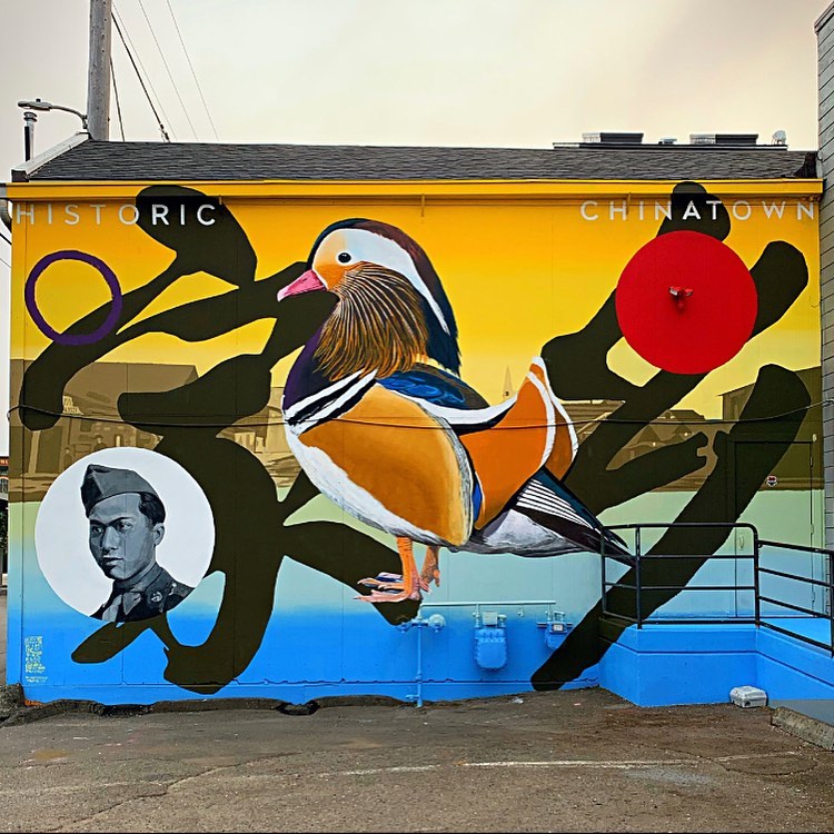 Picture of mural featuring a man, a bird, a blue and yellow background, and the words Historic Chinatown