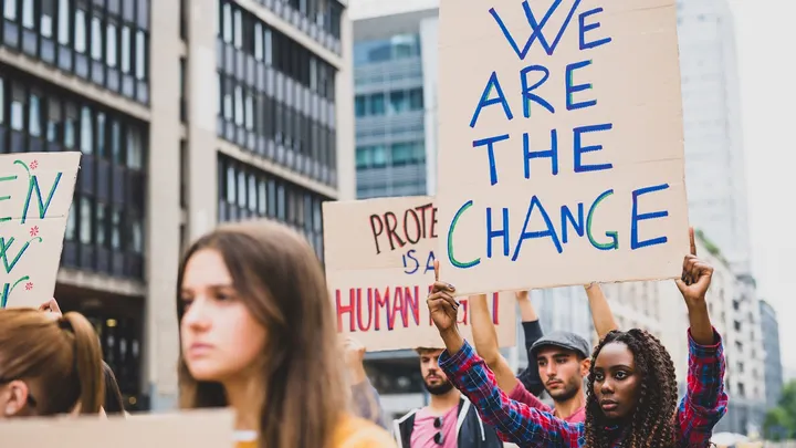 Pictures of people protesting holding signs saying "We are the change."