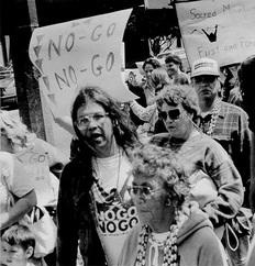 Black and white photo of activist and several others protesting.